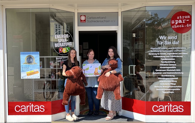 Vor dem neuen Caritas-Infoladen in der Marktstraße 11 freuen sich (v.l.) Ann-Kathrin Osburg, Elvira Werner und Madlen Dettenbach auf die Bärensuche am 6. Juli. | Foto: Caritas